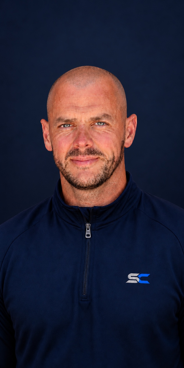 Conrad Prendergast, founder of SPORTCOMMON, wearing a navy top with the SC monogram